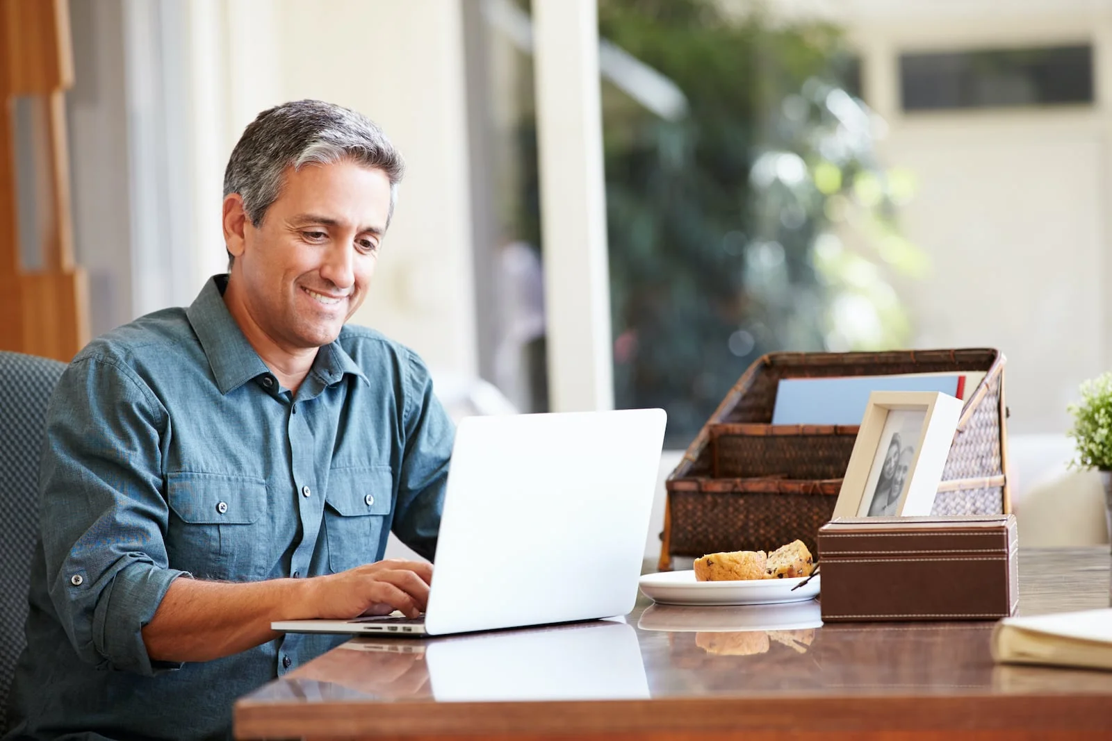 man at laptop smiling at desk